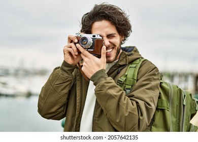 Handsome Hispanic Man Using Vintage Camera By Marina Port