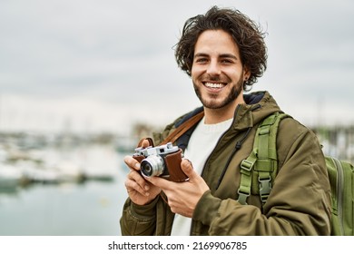 Handsome Hispanic Man Using Vintage Camera By Marina Port