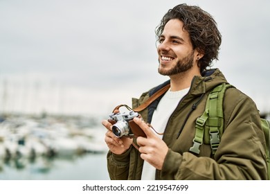 Handsome Hispanic Man Using Vintage Camera By Marina Port