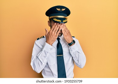 Handsome Hispanic Man Wearing Airplane Pilot Uniform Rubbing Eyes For Fatigue And Headache, Sleepy And Tired Expression. Vision Problem 