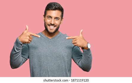 Handsome hispanic man wearing casual clothes looking confident with smile on face, pointing oneself with fingers proud and happy. 