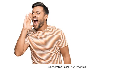 Handsome Hispanic Man Wearing Casual Clothes Shouting And Screaming Loud To Side With Hand On Mouth. Communication Concept. 