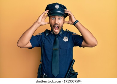 Handsome Hispanic Man Wearing Police Uniform Crazy And Scared With Hands On Head, Afraid And Surprised Of Shock With Open Mouth 