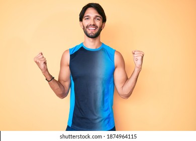 Handsome Hispanic Man Wearing Sportswear Screaming Proud, Celebrating Victory And Success Very Excited With Raised Arms 