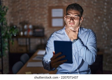 Handsome Hispanic Man Working At The Office At Night Touching Painful Neck, Sore Throat For Flu, Clod And Infection 