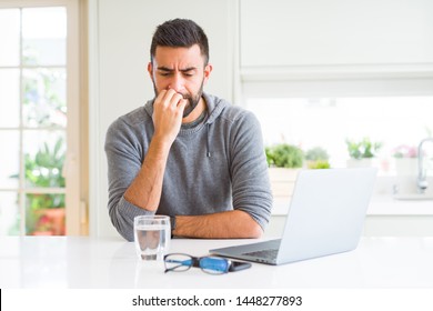 Handsome Hispanic Man Working Using Computer Laptop Looking Stressed And Nervous With Hands On Mouth Biting Nails. Anxiety Problem.