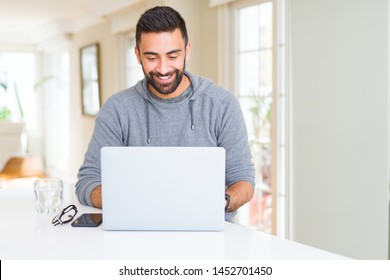 Handsome Hispanic Man Working Using Computer Laptop With A Happy Face Standing And Smiling With A Confident Smile Showing Teeth