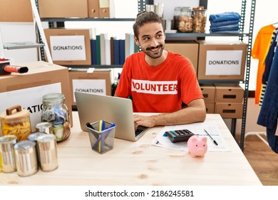 Handsome hispanic man working as volunteer doing countability at donation stand - Shutterstock ID 2186245581