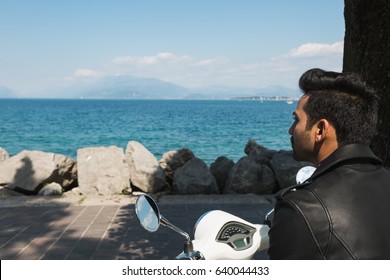 Handsome Indian Man Posing On A Scooter In A Vacation Context. Street Fashion And Style.