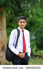 handsome Indian young boy wearing white shirt and red tie