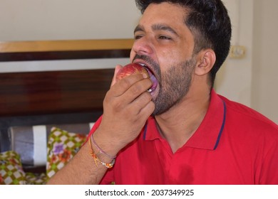 Handsome Indian Young Man Eating An Apple Closeup