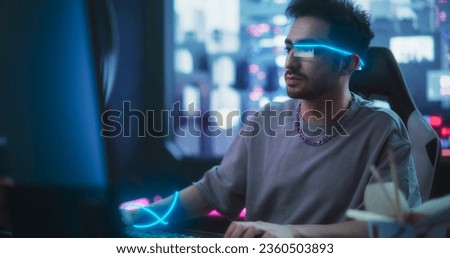 Handsome Influencer Working on Computer in His Stylish Sci-Fi Studio. Young Creative Genius Developing Innovative Software Technology. Man Wearing Futuristic Monocle Glasses with Extended Reality