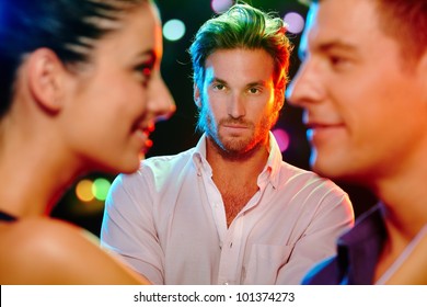 Handsome Jealous Man Looking At Flirting Couple On Dance Floor.