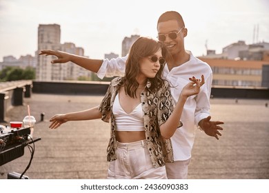 handsome joyful african american man dancing actively with his beautiful friend at rooftop party - Powered by Shutterstock