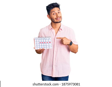 Handsome Latin American Young Man Holding Heart Calendar Smiling Happy Pointing With Hand And Finger 