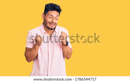 Handsome latin american young man wearing casual summer shirt excited for success with arms raised and eyes closed celebrating victory smiling. winner concept. 