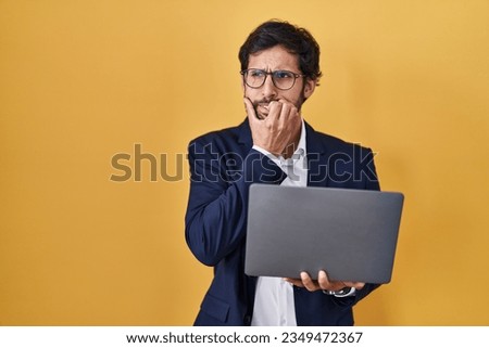Handsome latin man working using computer laptop looking stressed and nervous with hands on mouth biting nails. anxiety problem. 