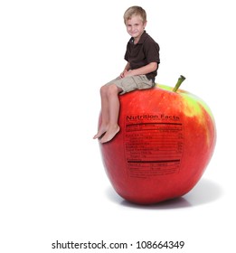 Handsome Little Boy Sitting On A Green Apple With A Nutrition Label