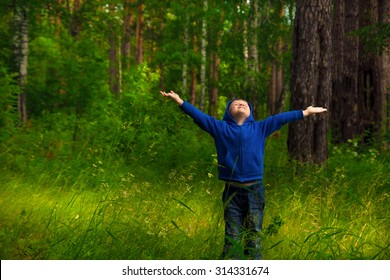 Handsome Little Happy Smiling Child (boy) Walking And Having Fun In The Green Forest (park) And Breathing Fresh Air