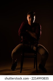Handsome looking at the camera while sitting at the studio