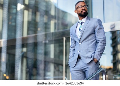 Handsome male african american business man CEO in a stylish chic suit at the workplace, standing confidently in front of financial building