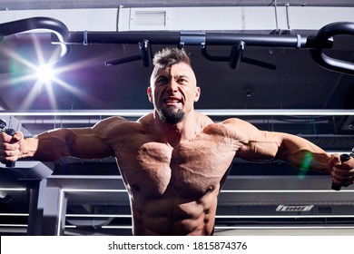 Handsome male bodybuilder in the gym. Big strong man during training in the gym. Guy with big muscles who is an athlete, trainer or instructor