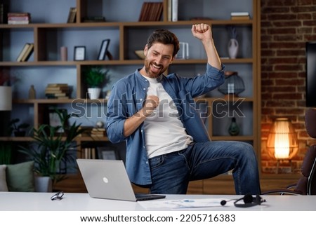 A handsome male businessman successfully completed his job and began to dance with pleasure in his home office. Dancing manager freelancer at the end of the working day after a successful project.