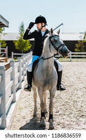 Handsome Male Equestrian Riding Horse At Horse Club And Touching Riding Helmet