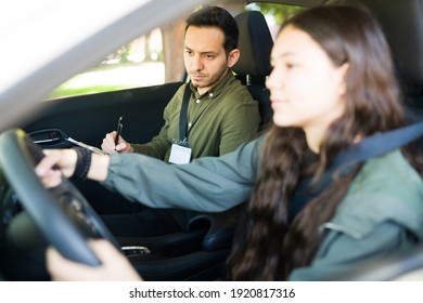 Handsome male instructor checking and testing the driving skills of a teenager girl during her exam to get her driver's license