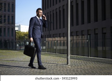 Handsome male marketing experts in elegant formal suit walking on city street going to visit meeting conference of business corporation to report about advantages of new creative advertising campaign - Powered by Shutterstock