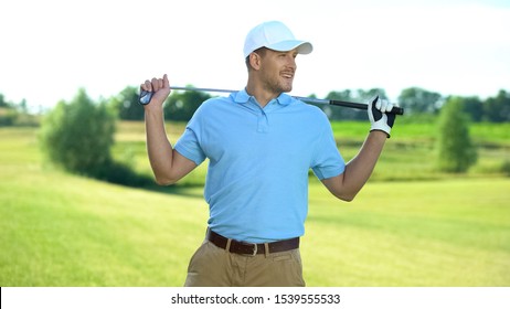 Handsome Male Player With Golf Club Behind Shoulders Smiling To Partner, Hobby