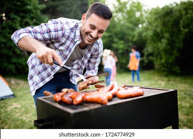 Handsome male preparing barbecue, grill outdoors for friends