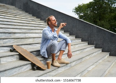 Handsome Male Skateboarder Smoking Weed In The Street