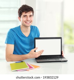 Handsome Male Student Showing Blank Screen Of Laptop Ready For Your Design