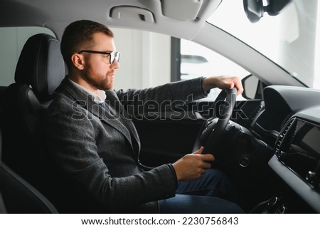 Handsome male taxi driver in car
