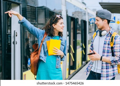 Handsome Male Traveler With Backpack And Smartphone In Hand Asking For Help Woman With At Tram Stop. Young Man Tourist Asking For Directions And Help From Local People In Tram Stop Outdoor.