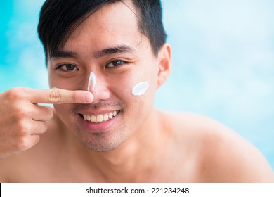 Handsome Man Applying Sunscreen On His Face