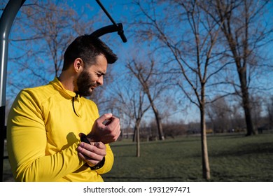 Handsome Man Athlete Having Hand Wrist Injury. Man Frowning In Pain