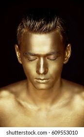 A Handsome Man Of Athletic Build, Completely Covered In Gold Paint.Studio Photos