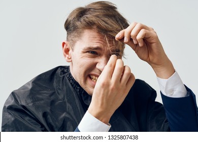 Handsome Man In A Barbershop Looks At His Hair With A Bad Haircut