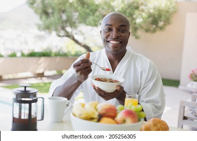 Handsome Man In Bathrobe Having Breakfast Outside On A Sunny Day