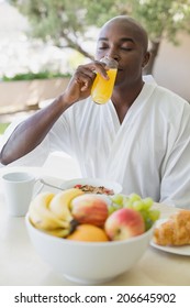 Handsome Man In Bathrobe Having Breakfast Outside On A Sunny Day