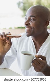 Handsome Man In Bathrobe Having Breakfast Outside On A Sunny Day