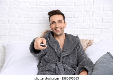 Handsome Man In Bathrobe Watching TV On Bed