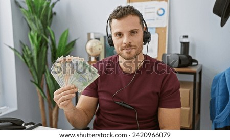 Handsome man with beard holding romanian currency in a modern office setting