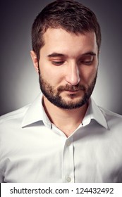 handsome man with beard looking down. studio portrait over dark background