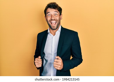 Handsome Man With Beard Wearing Business Suit Holding Jacket Celebrating Crazy And Amazed For Success With Open Eyes Screaming Excited. 