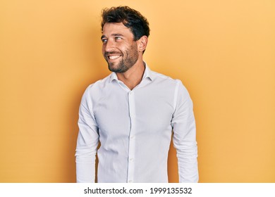 Handsome Man With Beard Wearing Casual White T Shirt Looking To Side, Relax Profile Pose With Natural Face And Confident Smile. 