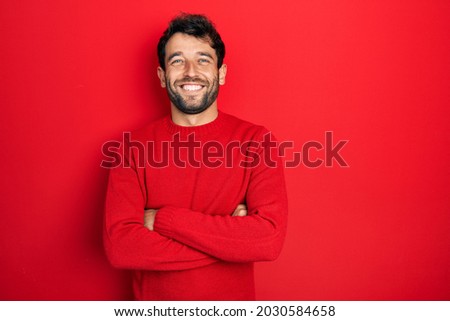 Handsome man with beard wearing casual red sweater happy face smiling with crossed arms looking at the camera. positive person. 