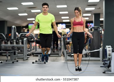 Handsome man and beautiful sporty woman workout with jumping rope in crossfit gym - Powered by Shutterstock